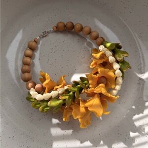 Burnt yellow hibiscus with pakalanas and pikake car lei